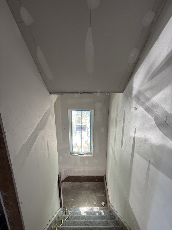 A taped stairwell and ceiling ready for sanding