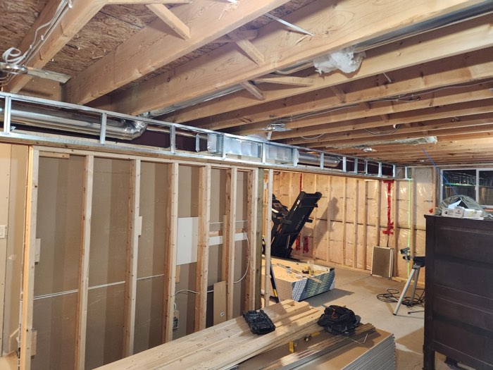 New basement wall framing under exposed joists by JW Drywall