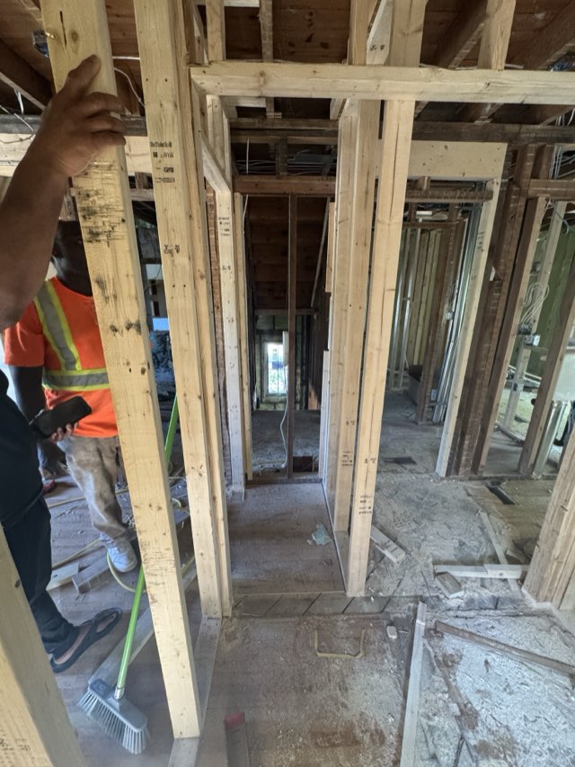 Tradespeople on site in a hallway of new stud framing during a Kitchener renovation