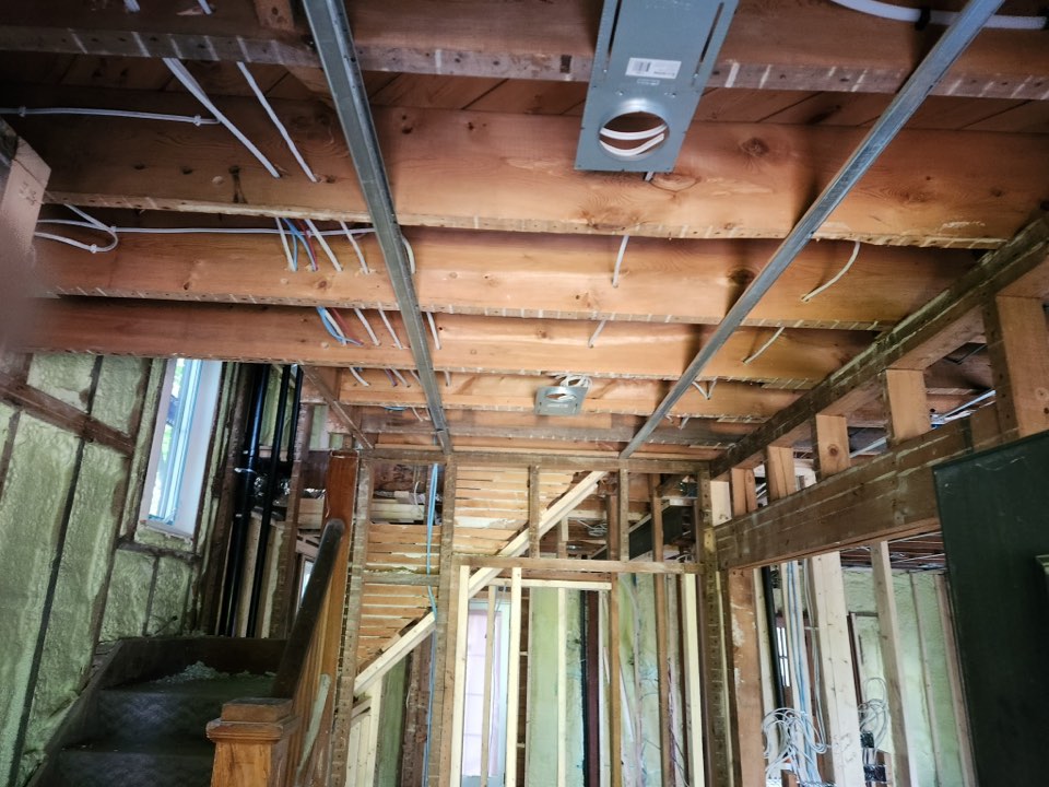 New electrical wiring and a pot light housing between ceiling joists